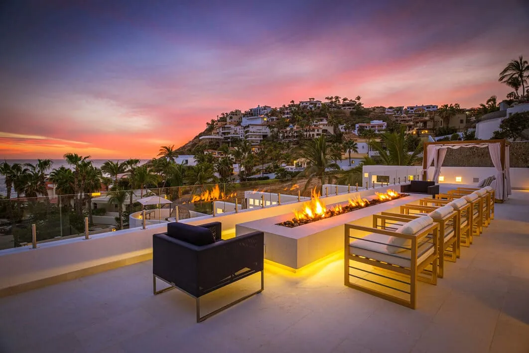 Rooftop firepit lounge at sunset with panoramic hillside and ocean views at Casa Aqua Blanca