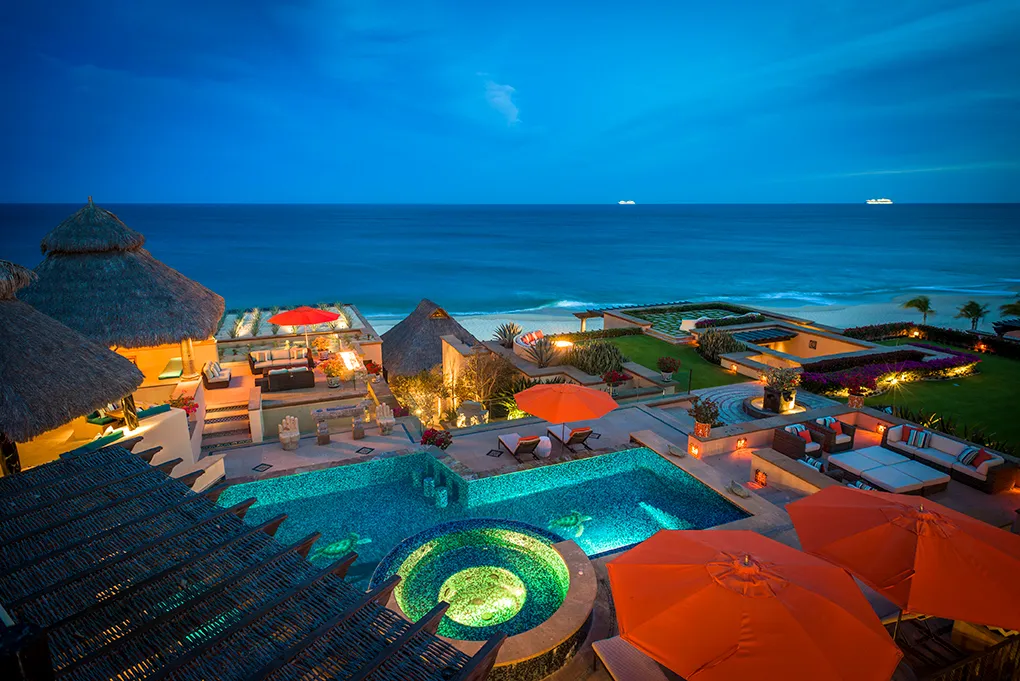 Elevated night view of Casa Hidalgo's pool, terraces and beachfront grounds