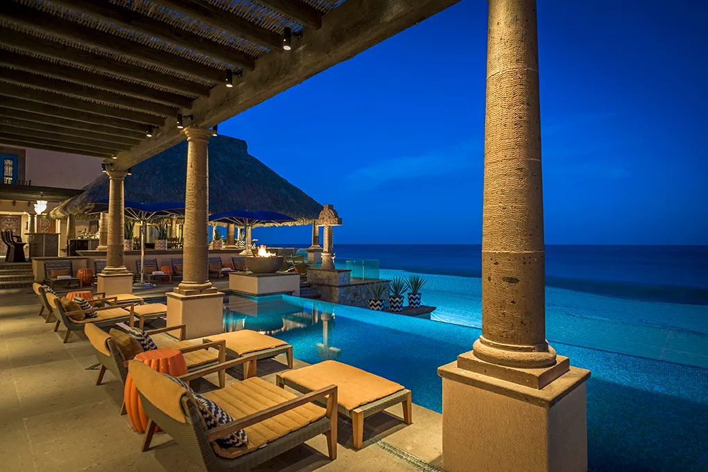 Casa Hidalgo oceanfront pool terrace illuminated at night in Los Cabos