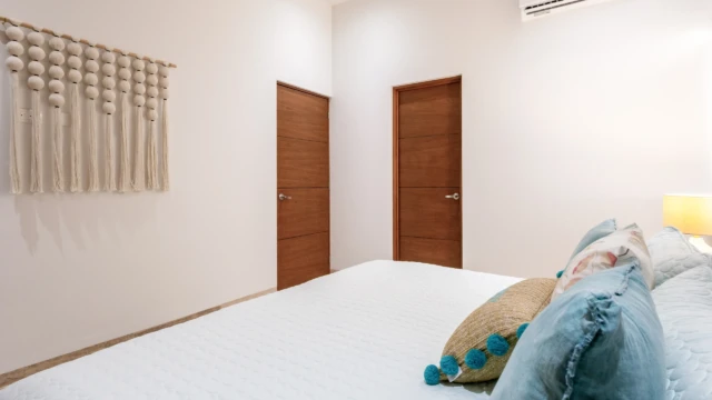 habitacion puertas madera dunas condo Bedroom detail showing two wooden doors, air conditioning, and a macrame wall decor.