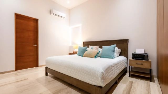 segunda habitacion renta vacacionaldunas condo Second bedroom with a double bed, wooden headboard, air conditioning, and nightstands.